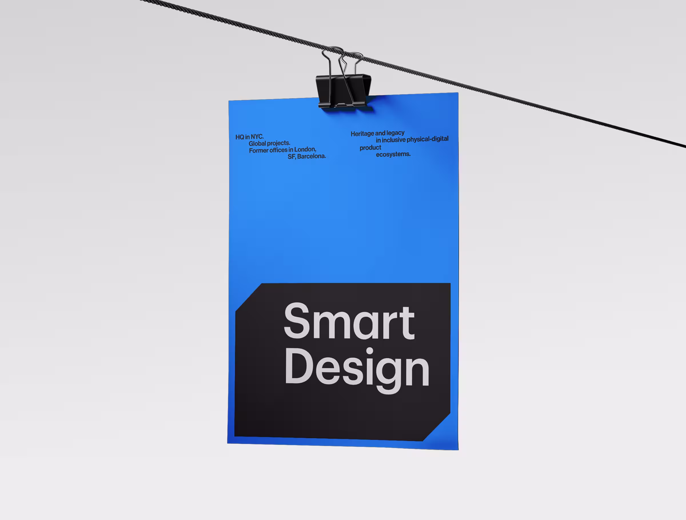 Blue poster with a black geometric block displaying ‘Smart Design,’ hanging from a clipped wire against a clean light background