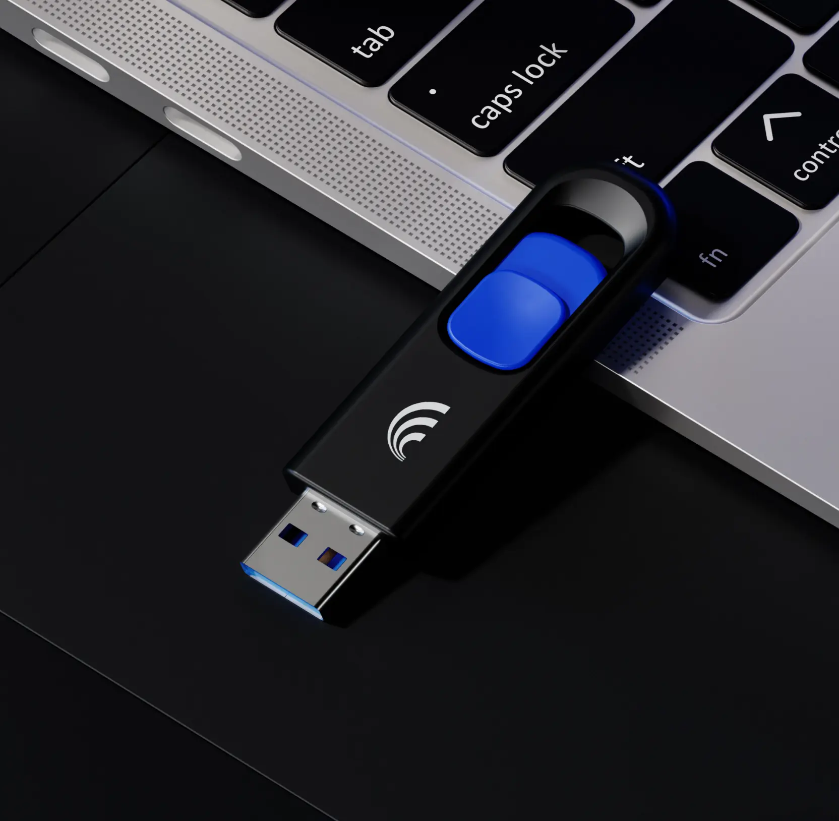 Black USB flash drive with the Dynascale arc mark and a blue slider, resting on a laptop