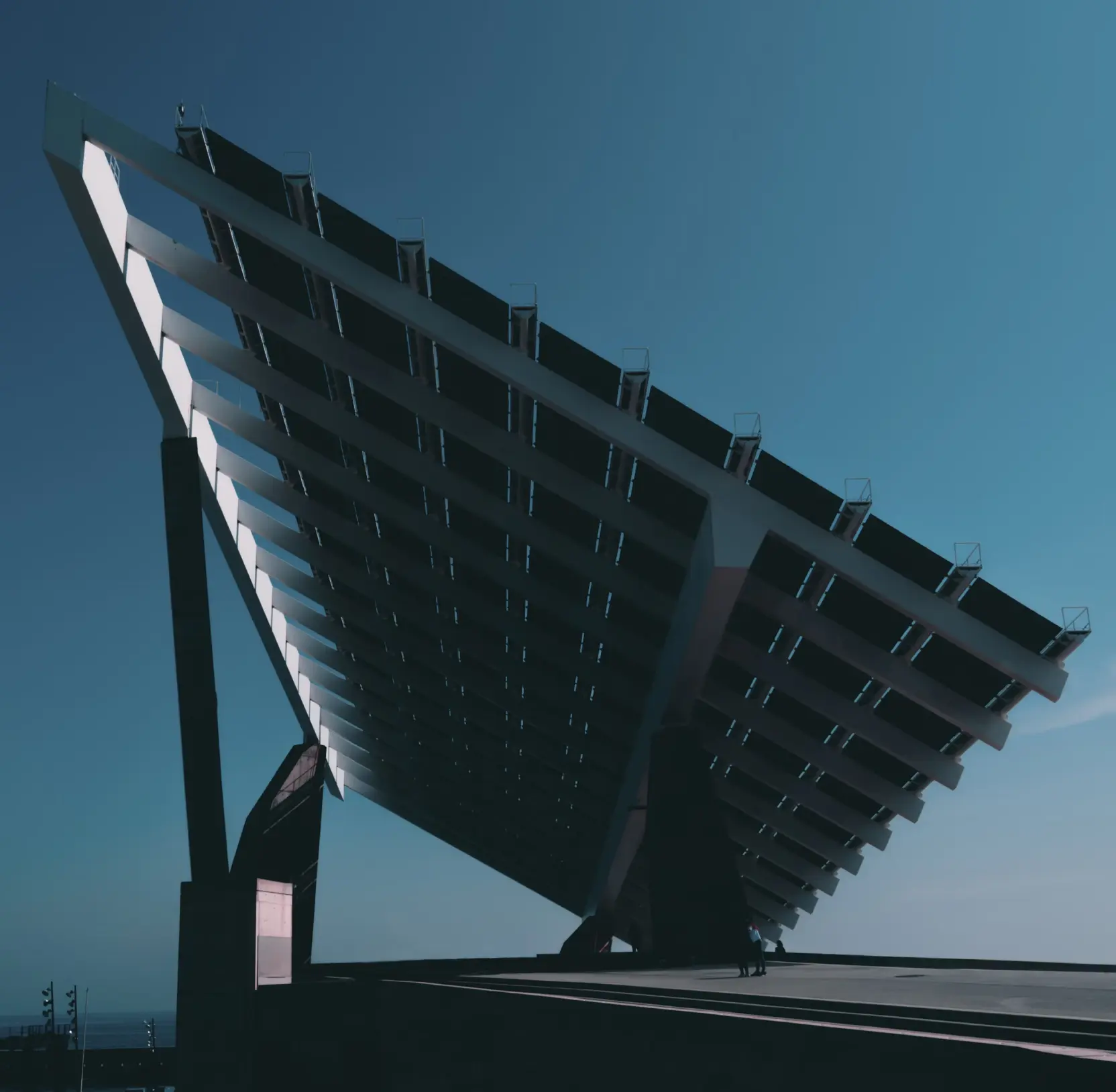 Angled solar tracker panel mounted on a frame against a clear blue sky